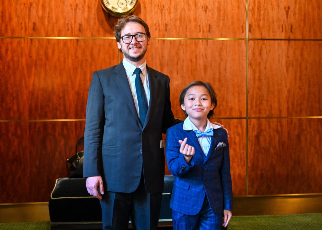 dr. misha tumanov with his piano student smiling for a photo