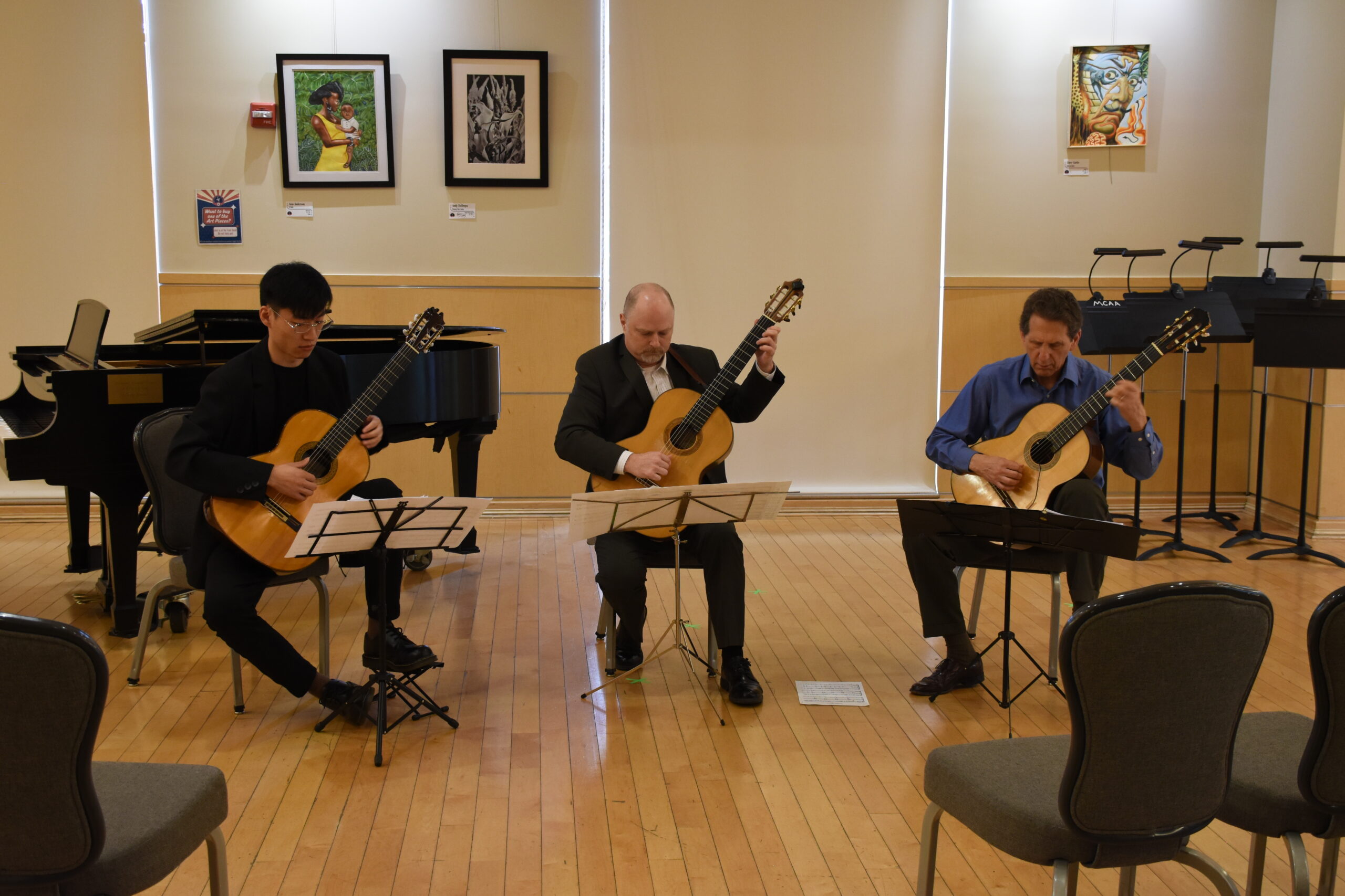 three guitar teachers performing on stage
