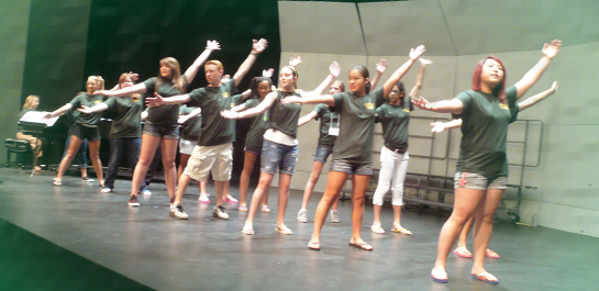 Students singing on stage at summer camp
