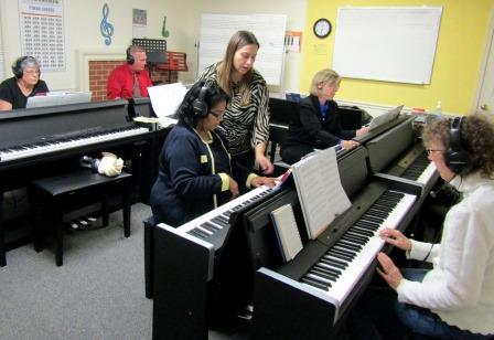 Piano Teacher teaching adult piano class