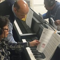 Piano instructor teaching adult students