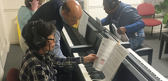 Piano instructor teaching adult students