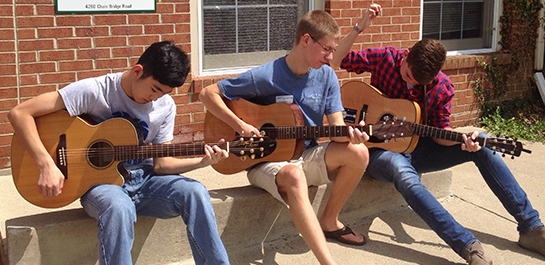 Students playing guitars at Songwriting camp