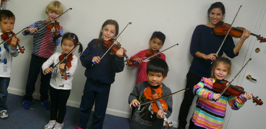Students with instructor in violin class