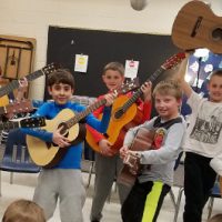 Students playing donated guitars