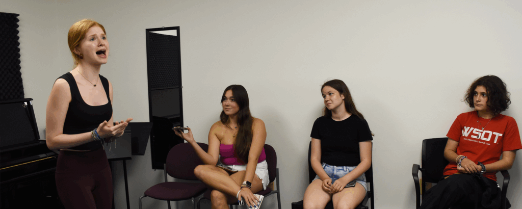 students watching a student recite a monolgue