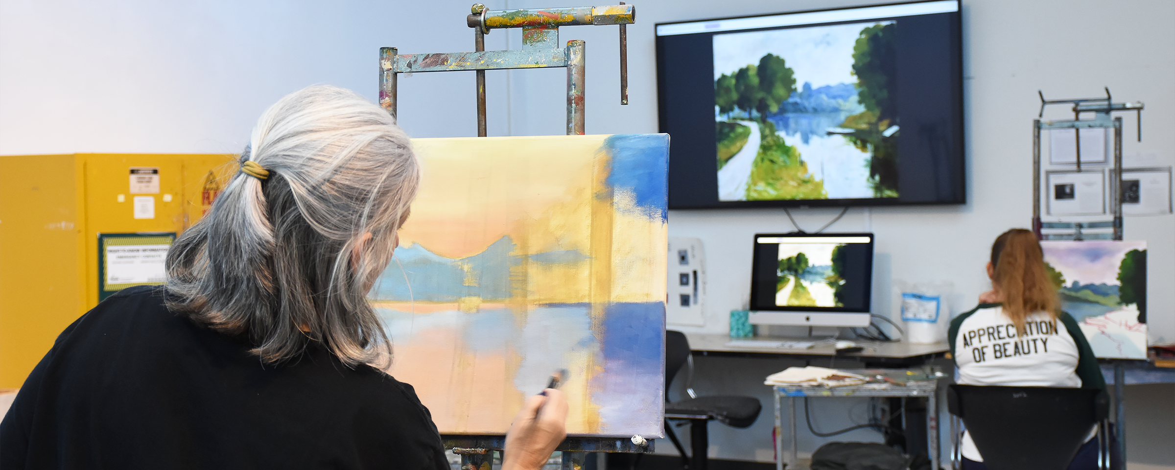 Two adult painting students working on their paintings