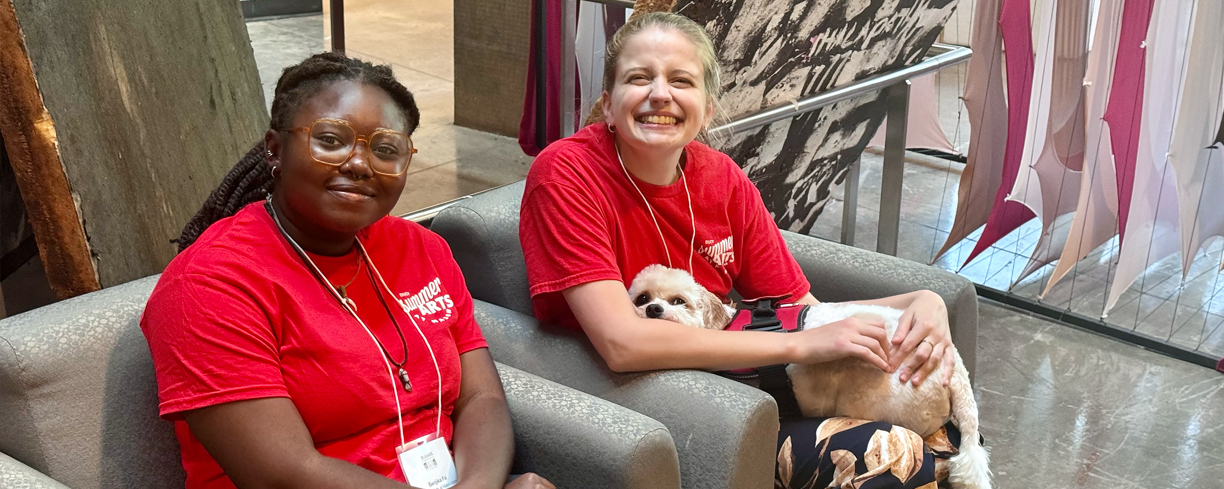 Two interns sitting an smiling for the camera