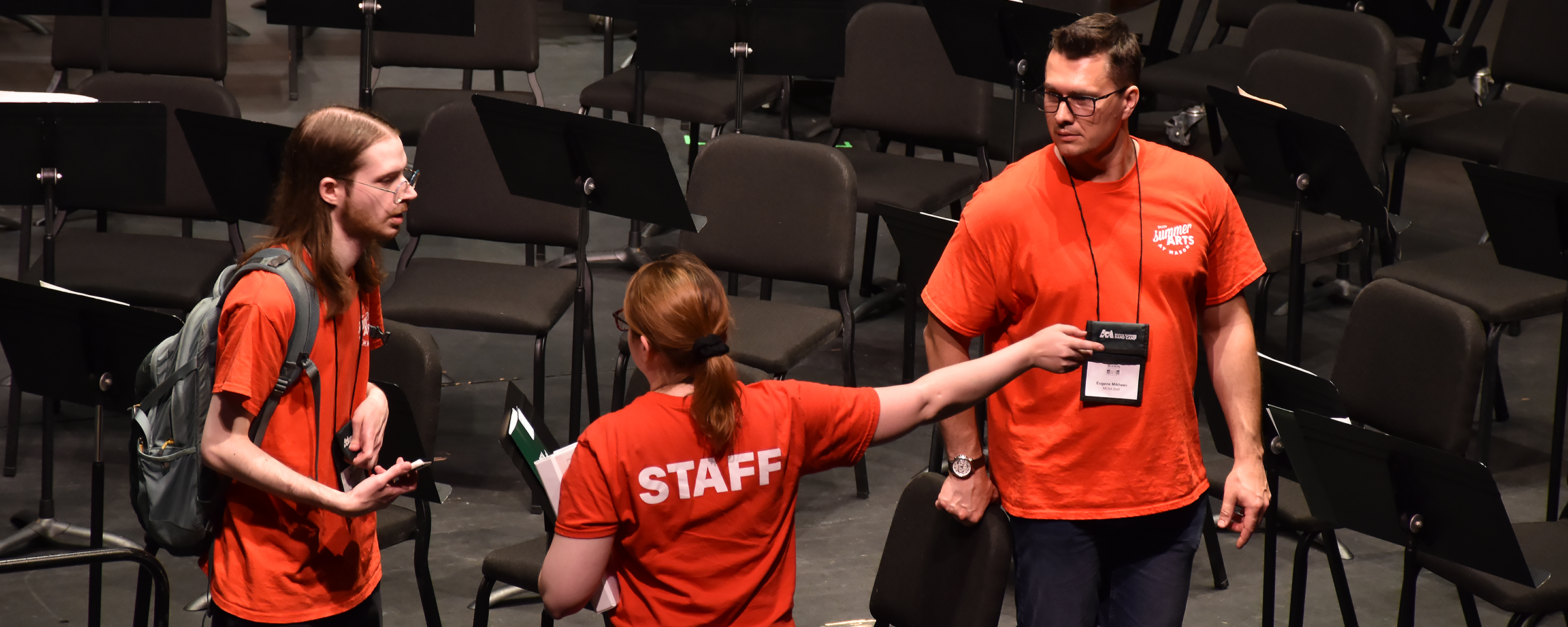 Staff members on stage figuring out seating locations for a performance