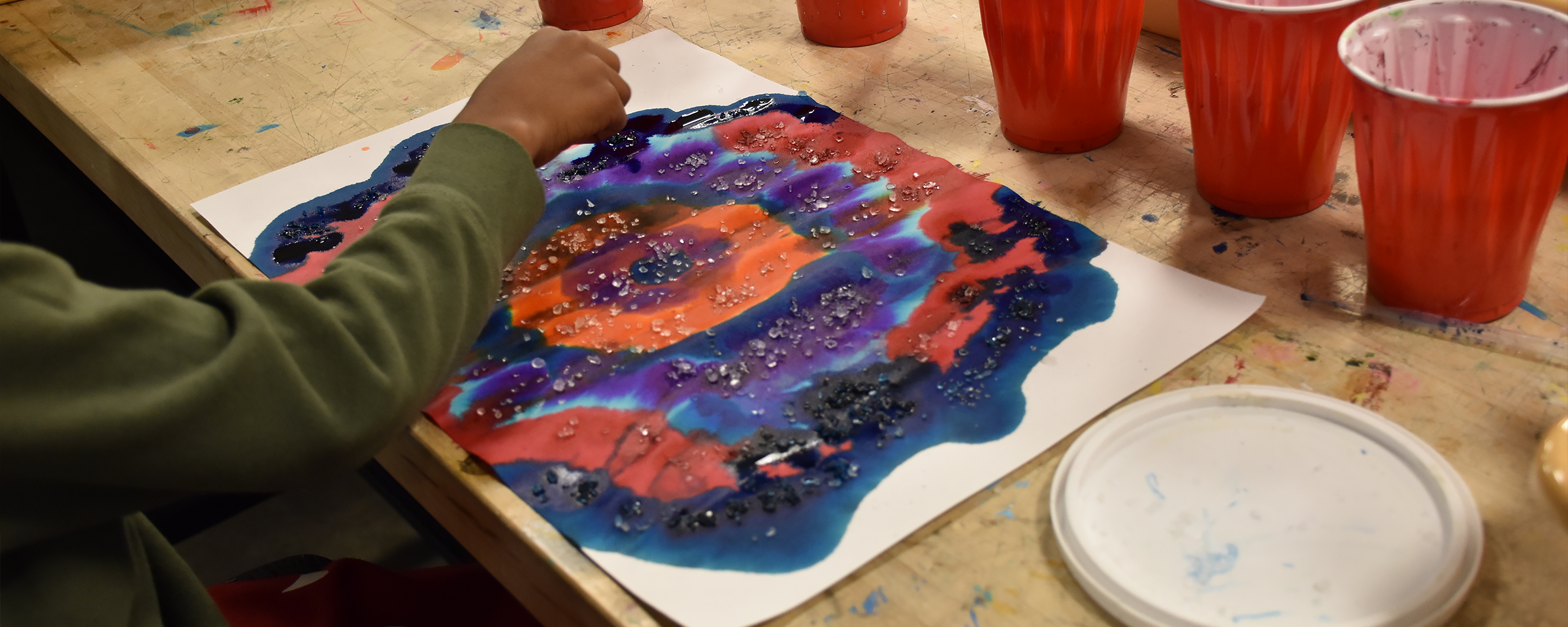 a child working on a water color painting.