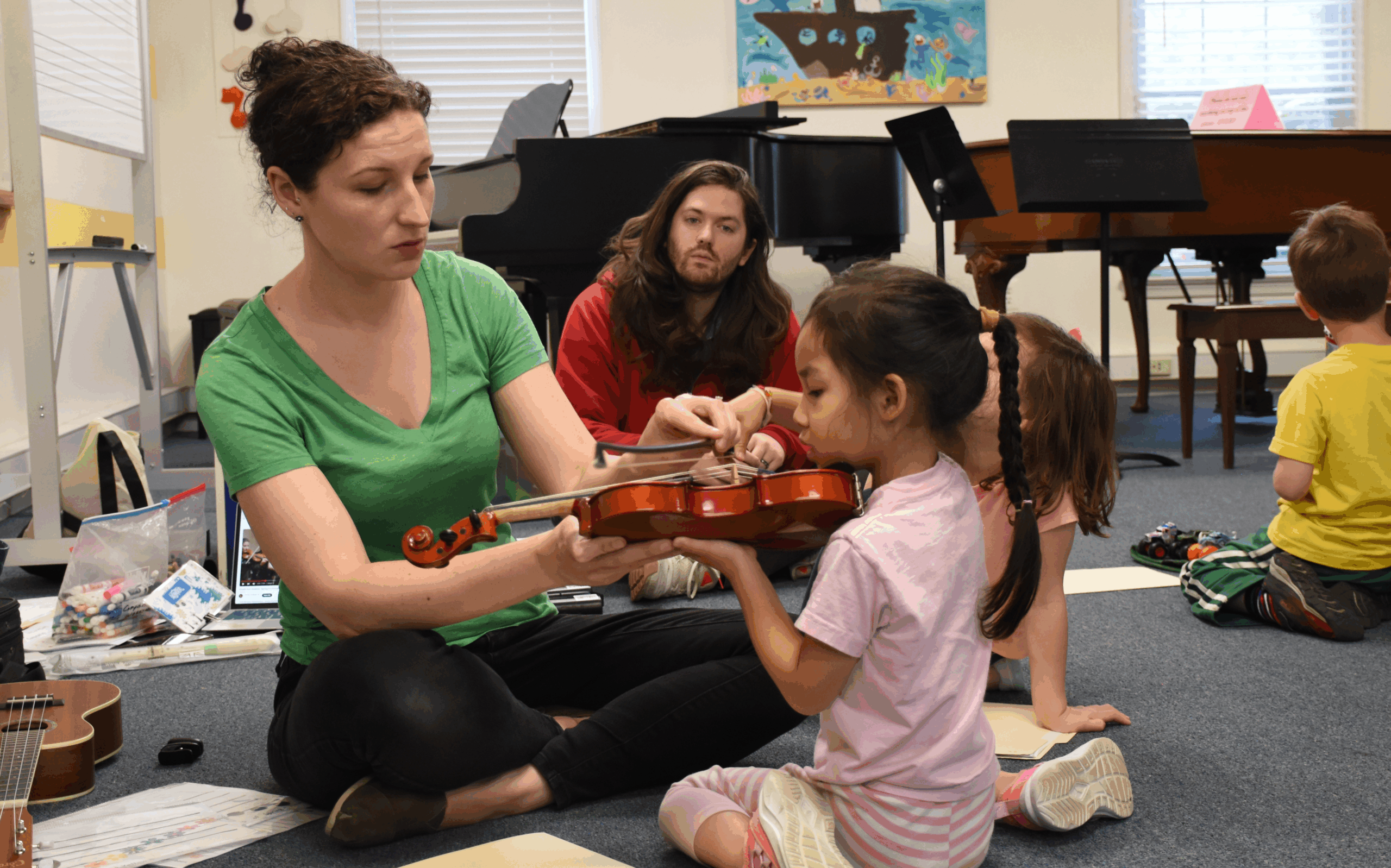 teacher showing student how to hold the violin