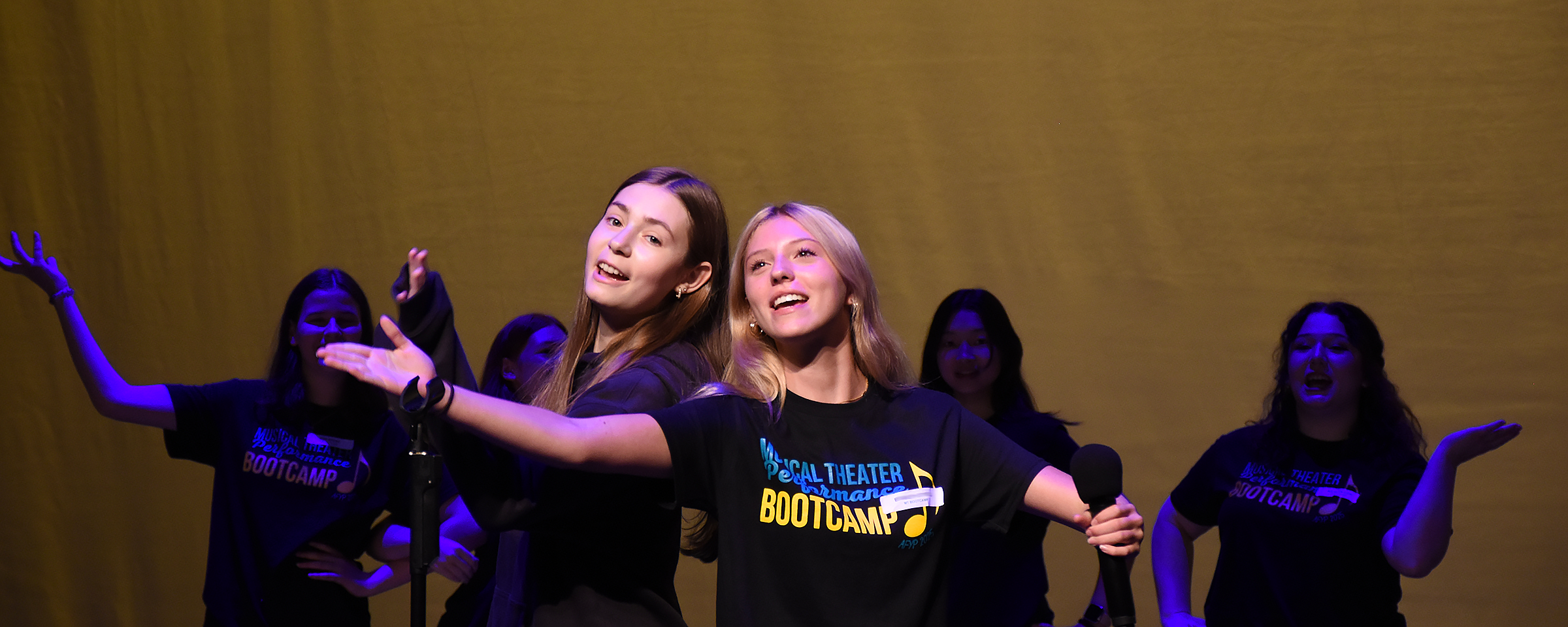 students performing on stage singing