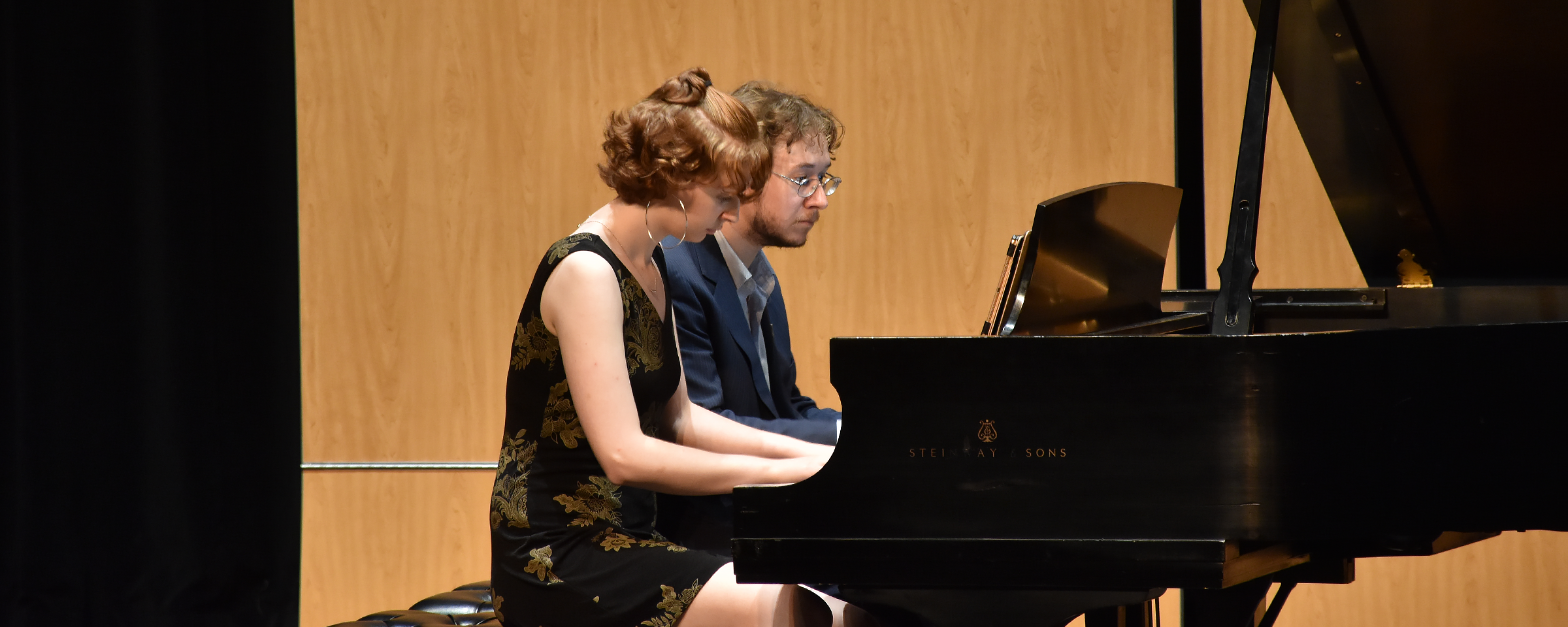 two pianists playing a duet on stage