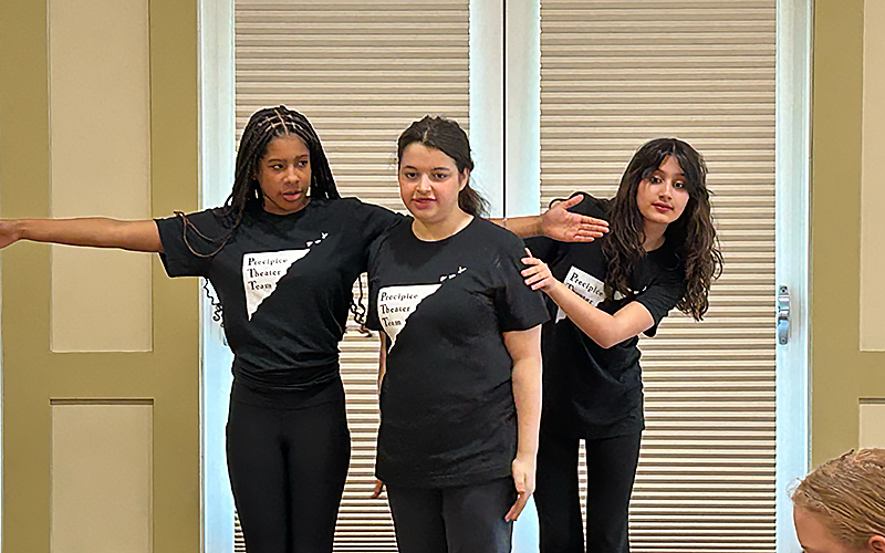 three students posing during a scene