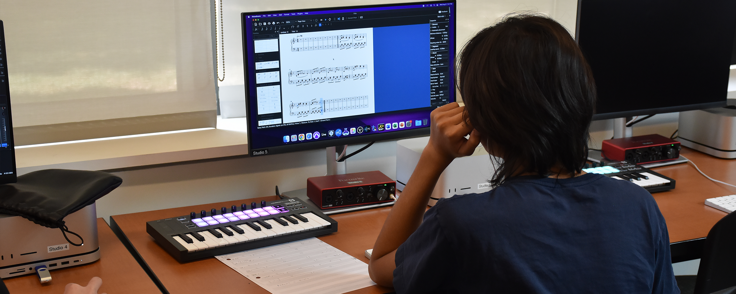 student working on their composition on a computer software